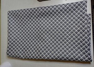 a képen gyöngyvászon anyag van, amit fehér, szürke és fekete V minták töltik ki