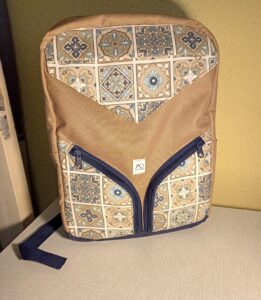 A képen egy lekerekített álló téglalap alakú hátizsákot látunk előlről, aminek eleje és oldala világosbarna, elekén alul 2 db cipzáras zseb van közép irányba lefelé ívelnek. A táska elején fölül egy lehajtható zseb van, ami mágneszárral csukódik. A zsebek világosbarna-kék marokkói csempemintásak.