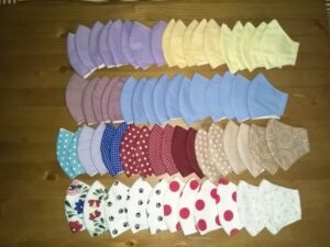 A képen rengeget (több, mint 60 darab) arcmaszk látható 18 különböző színben és mintában.